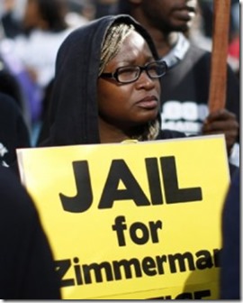 a-woman-holds-a-sign-calling-for-the-arrest-of-george-zimmerman-during-a-protest-in-los-angeles